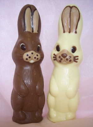 A picture of two bunny rabbits. One milk, and one white chocolate. Each decorated with white, milk and dark chocolate.