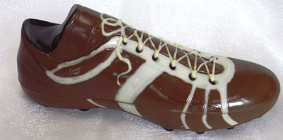 a picture of a milk chocolate football boot decorated with white and dark chocolate