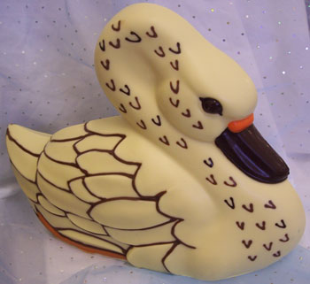 a picture of a white chocolate swan decorated with milk dark, and coloured chocolate